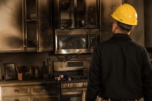 technician looking at fire damage in a kitchen 